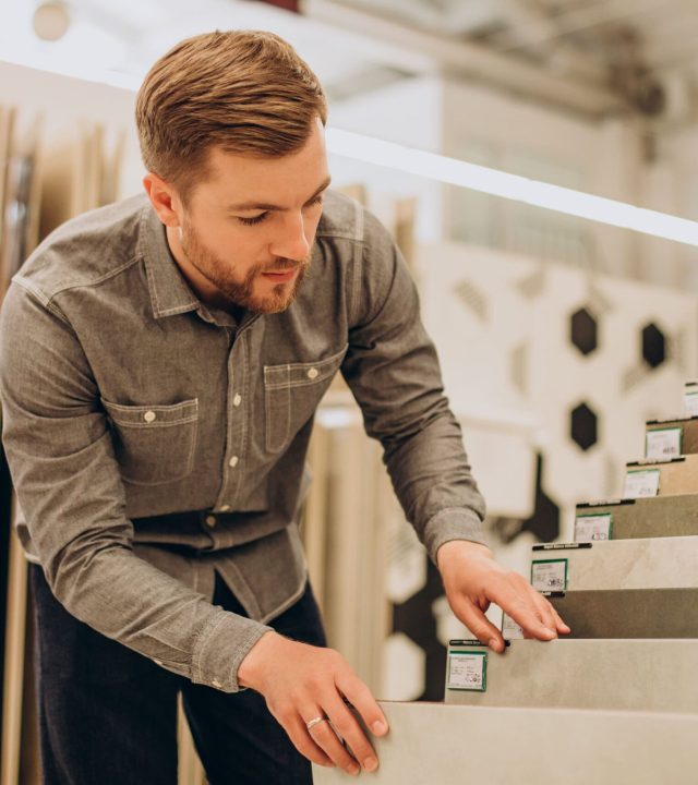 young-man-choosing-tiles-building-market